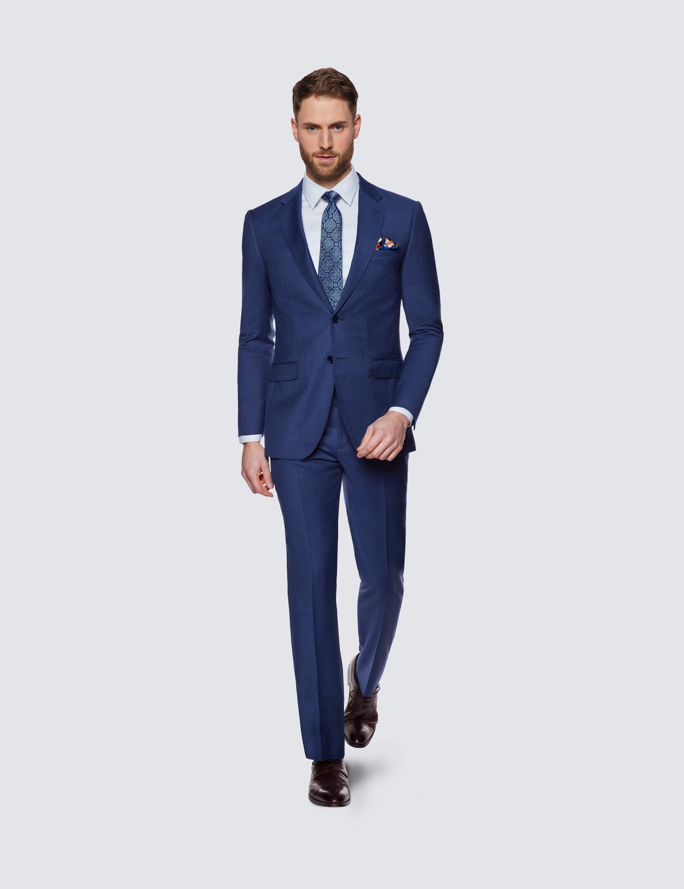 With white shirt, navy blue tie, cobalt blue jacket and brown